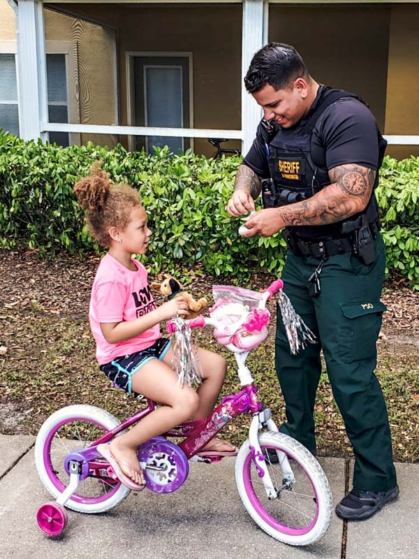 Officer with a little girl on a bike